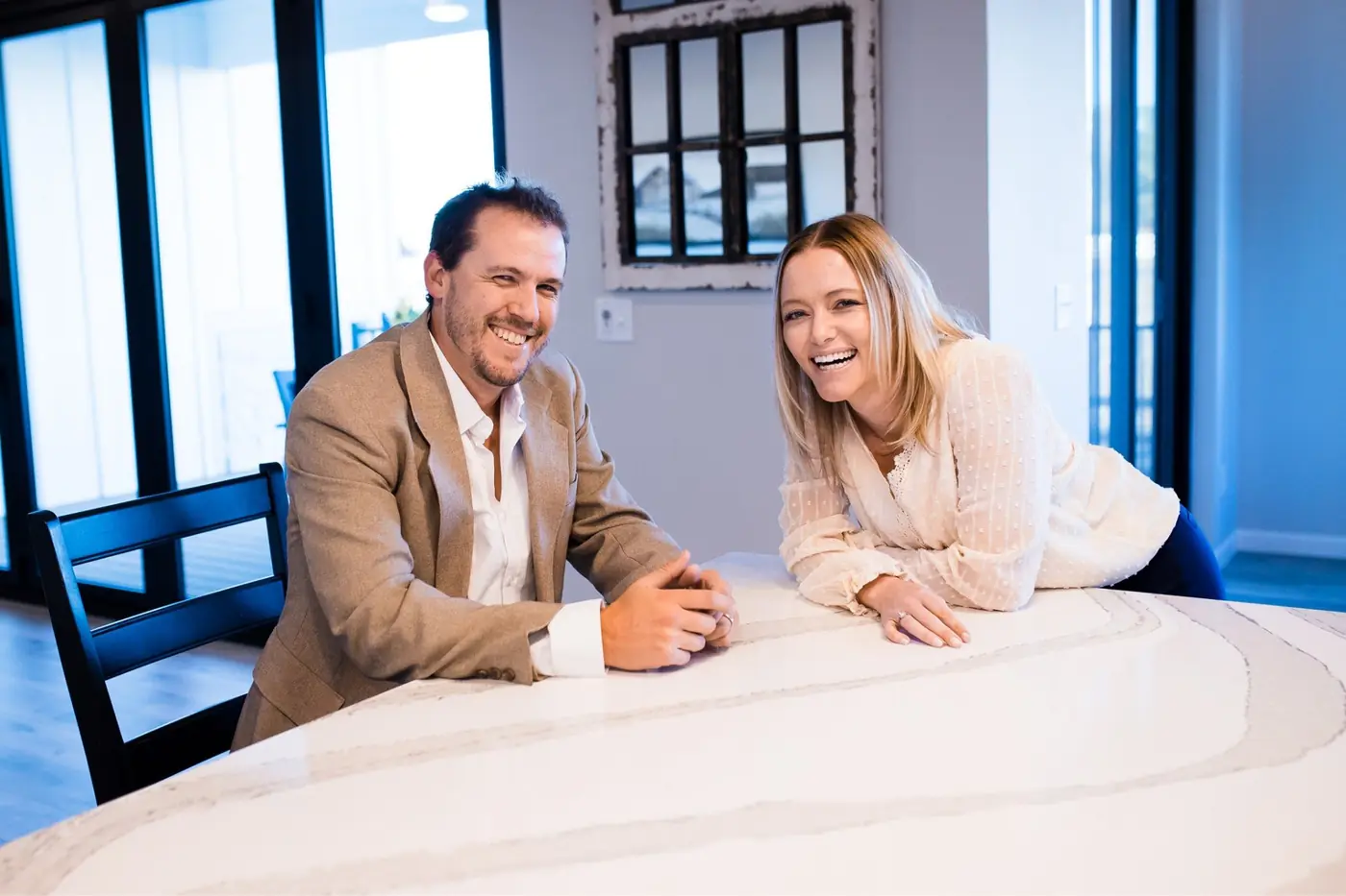 Adam Schwartz and a colleague laughing together at a kitchen counter.